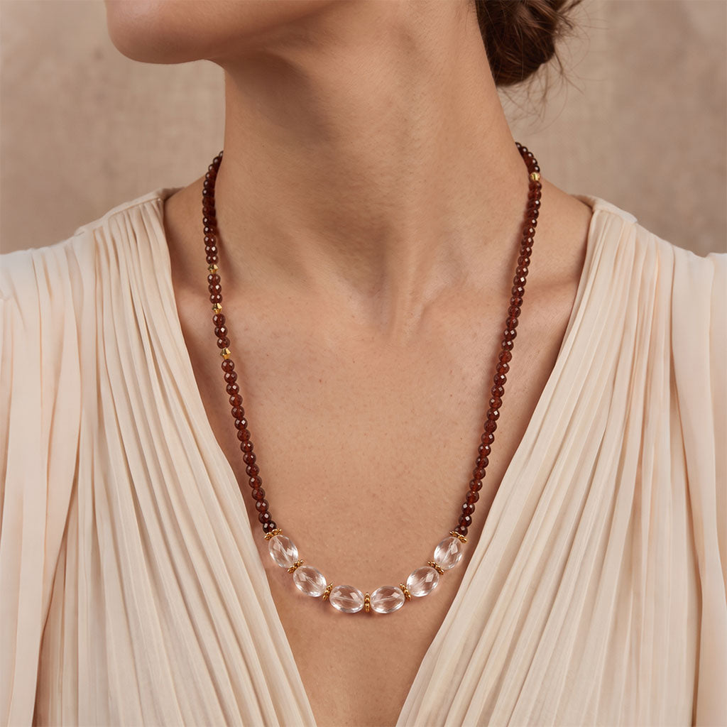 Woman wearing Garnet & Clear Quartz Energy Necklace with a minimalist elegant outfit