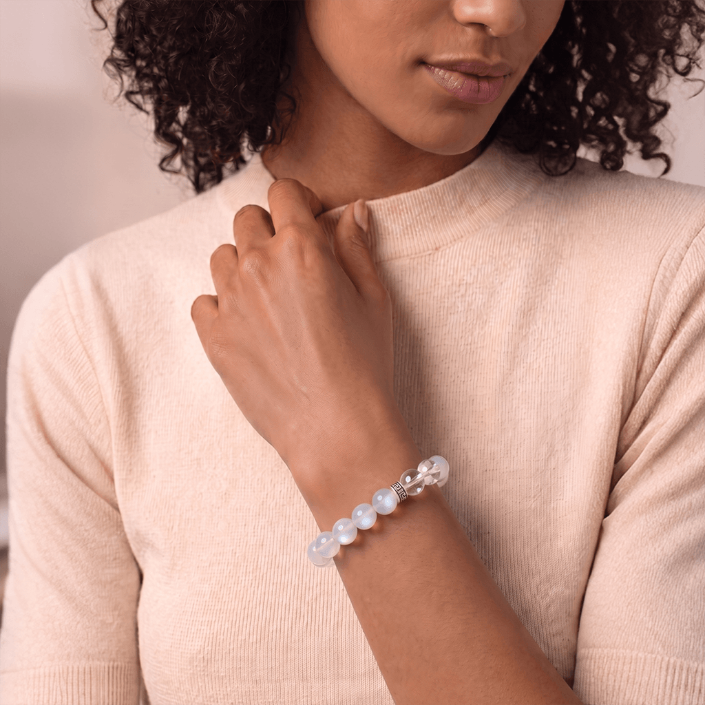 A woman wearing a Litchi Moonstone demonstrates the bracelet's effects.